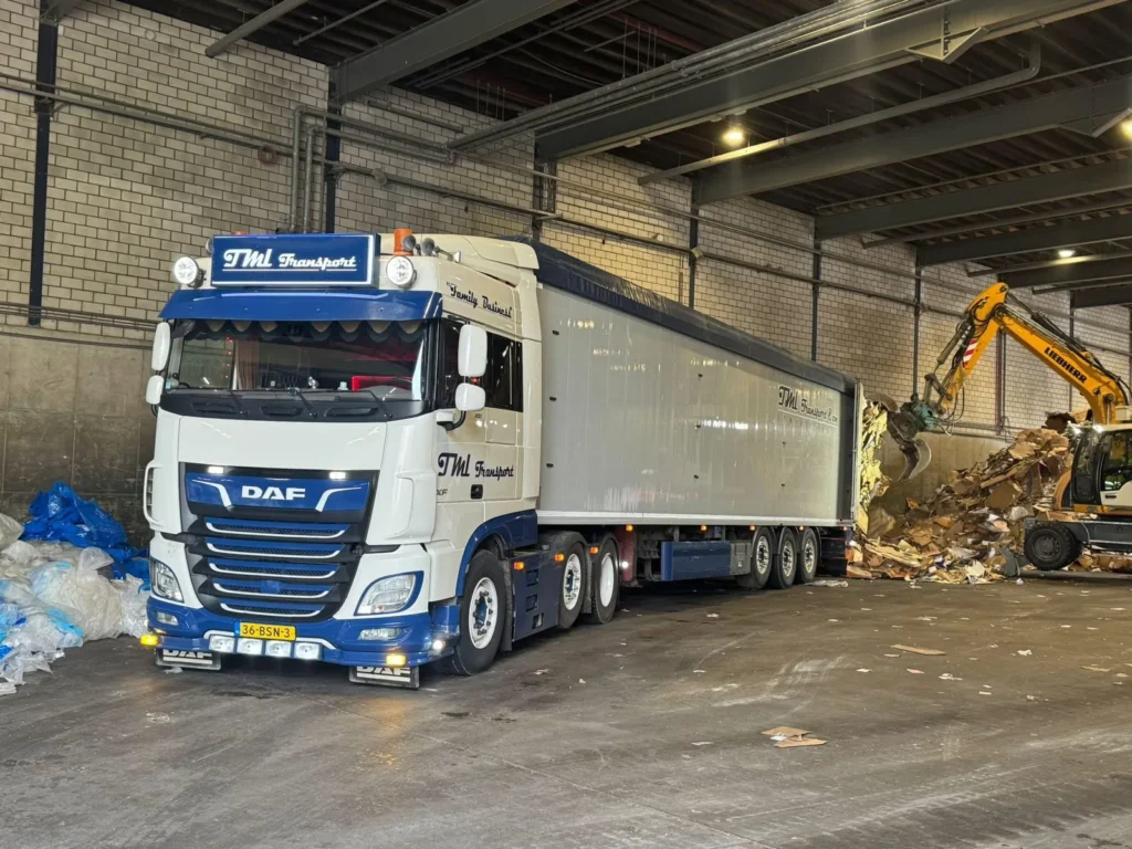 DAF walking floor combinatie van TML Transport wordt geladen in een recyclinghal