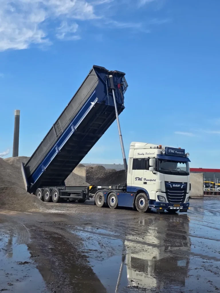 Kippertrailer van TML Transport lost los gestort materiaal op een overslaglocatie