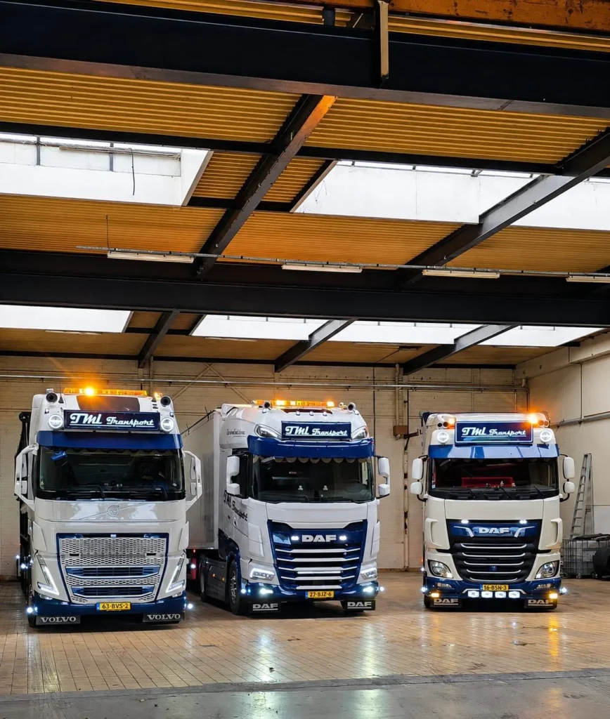 Drie vrachtwagens van het wagenpark van TML Transport naast elkaar in de loods