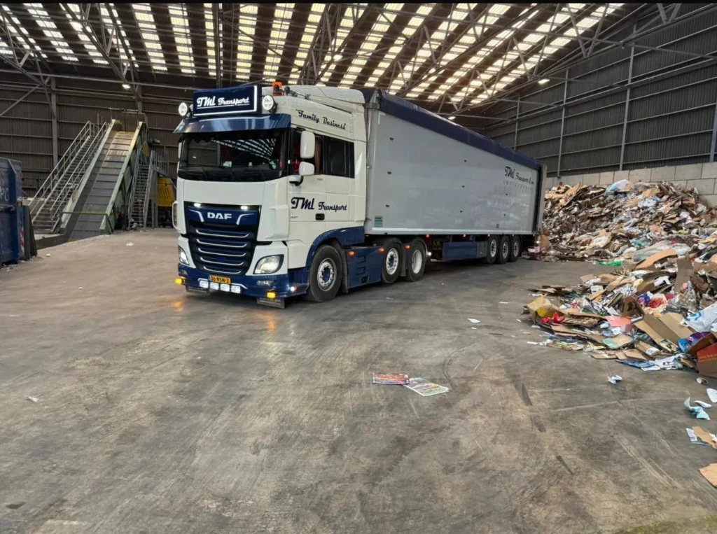 Walking floor trailer van TML Transport lost papier en karton bij een recyclingbedrijf